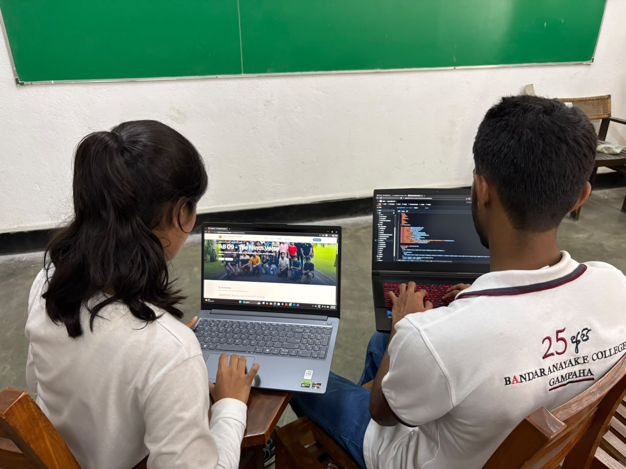 Two committee members coding the site on laptops